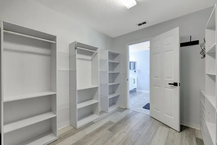 Customizable built-in shelving, hanging rods, and wood-finish flooring