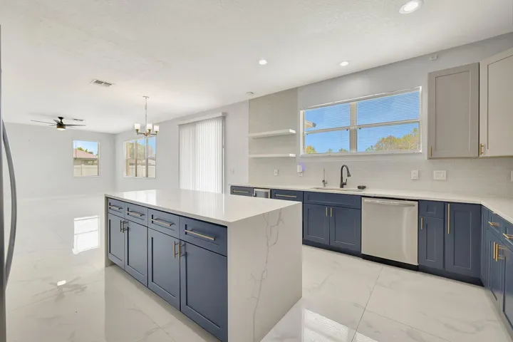 Kitchen featuring a waterfall island with a stone finish, stainless steel appliances, recessed lighting, and a chandelier
