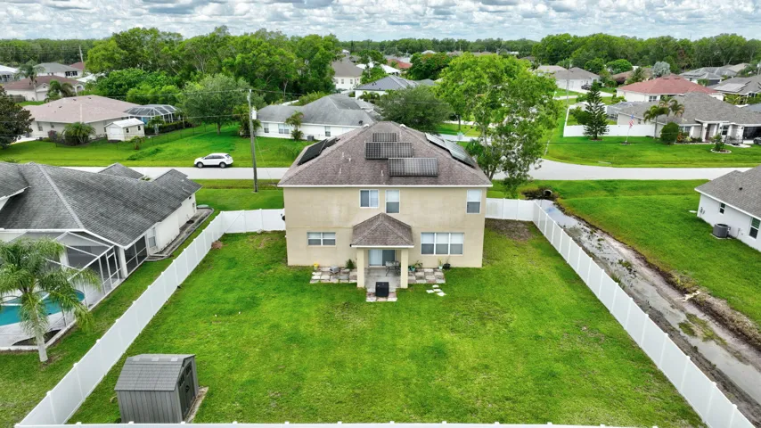 Two-story stucco exterior with a gabled roof, rear patio, and a spacious fenced yard