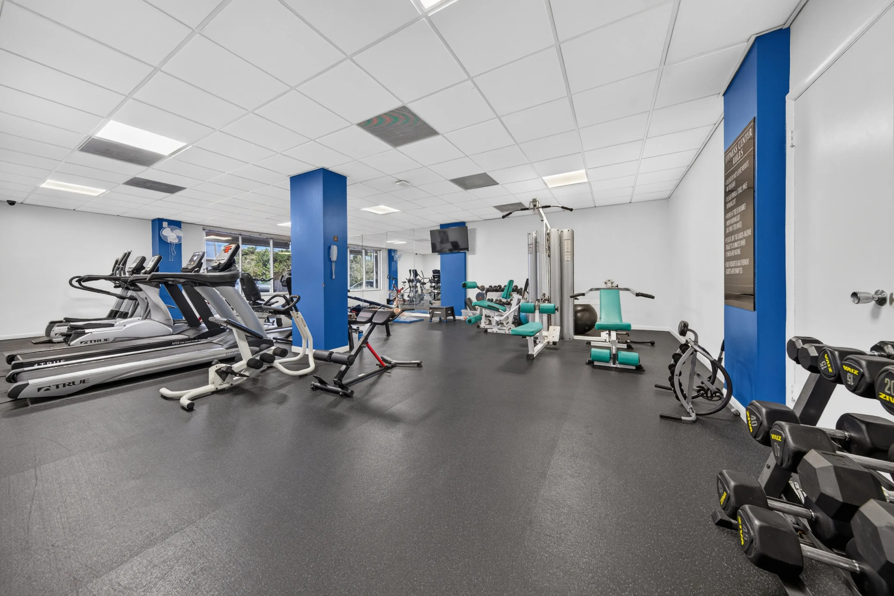 Spacious fitness facility equipped with treadmills, free weights and a variety of exercise stations.