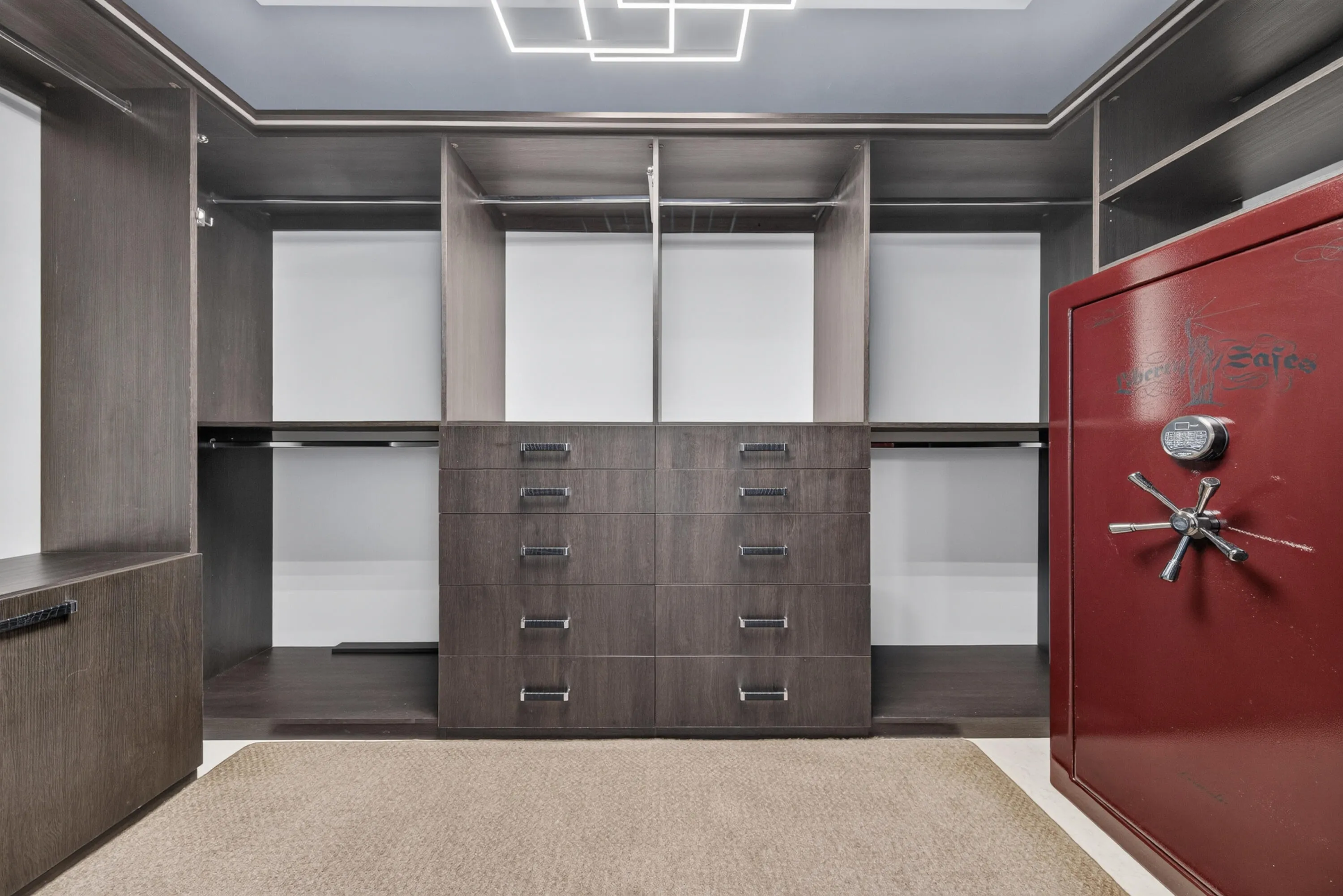 Custom-fitted primary walk-in closet with extensive built-in storage and an included full-size safe.