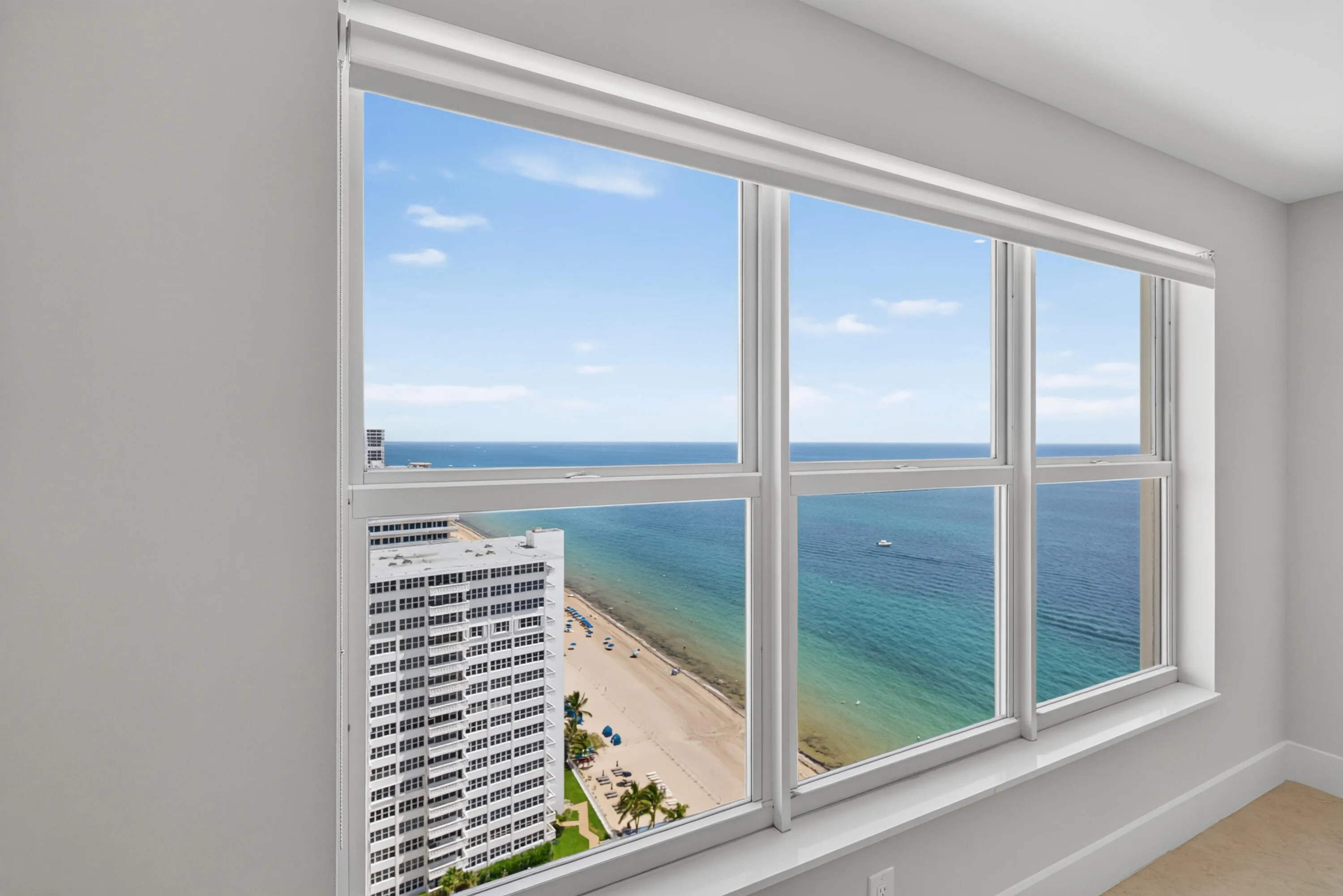 Upgraded high-impact windows frame sweeping ocean and coastline views from the guest bedroom.