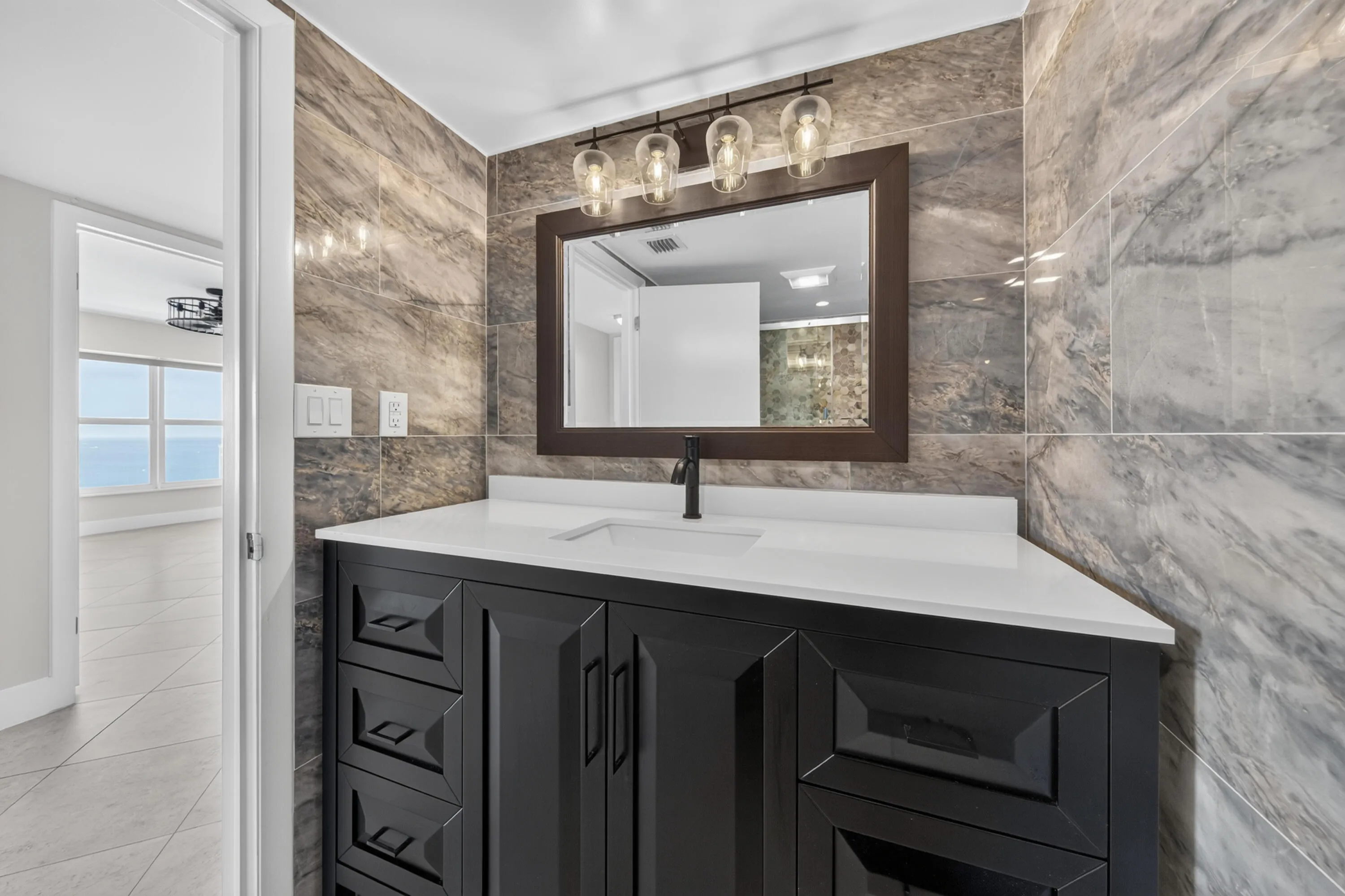 Stylishly updated bathroom featuring a contemporary vanity, quartz countertop and dramatic designer tile.