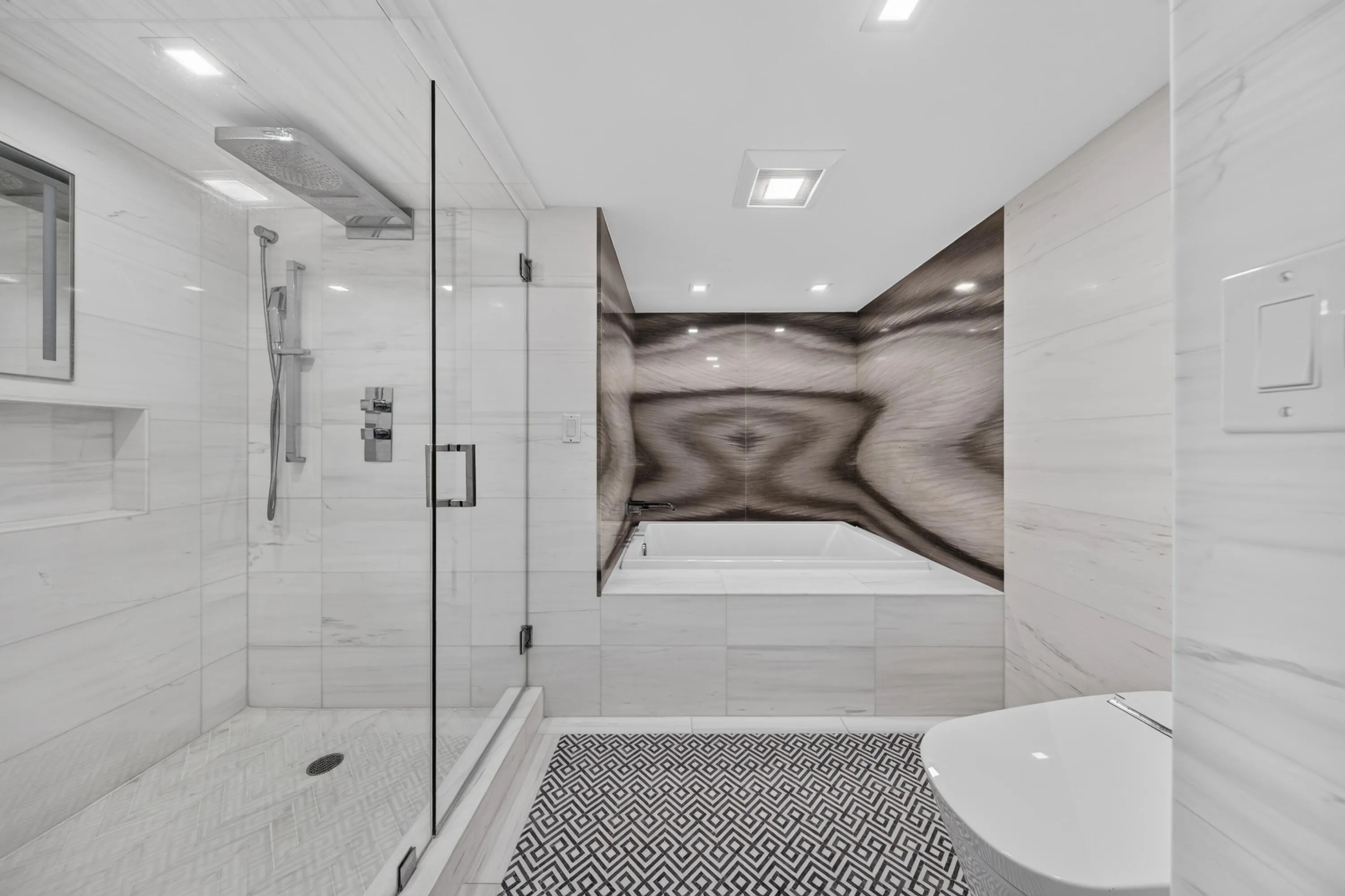 Relax in the deep soaking tub surrounded by dramatic book-matched stone-look walls and refined fixtures.