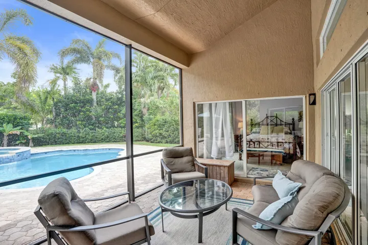 Screened patio with textured walls, vaulted ceiling, and recessed lighting