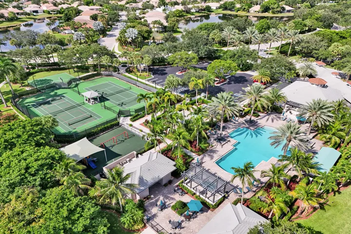 Community amenities featuring multiple tennis courts, a swimming pool, a playground, lush landscaping, and surrounding bodies of water