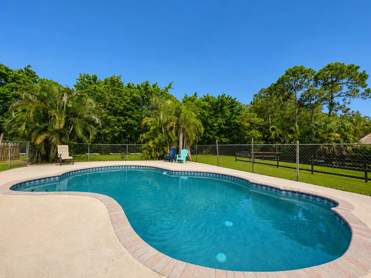 Crystal Clear Fenced In Pool Connected to Cover Patio, Outdoor Dining, Fire Pit Area and overlooking Barn 1, Paddocks and Flat Work Area