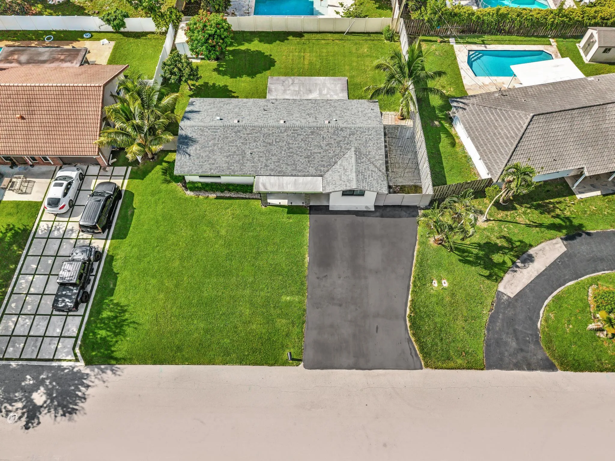 Oversize front lawn with a paved driveway
