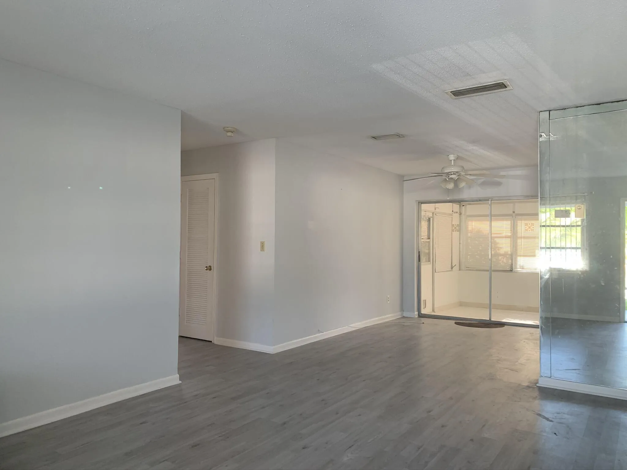 Wood-finish flooring, white walls, and a ceiling fan