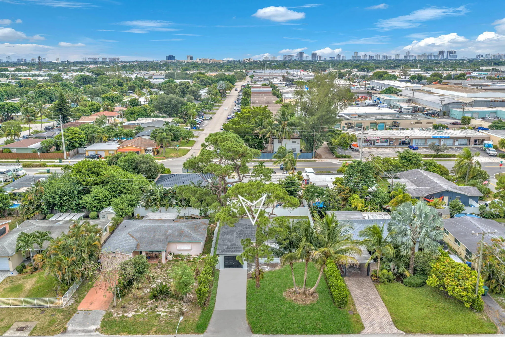 Aerial perspective of the property featuring a long driveway, mature trees, and established landscaping