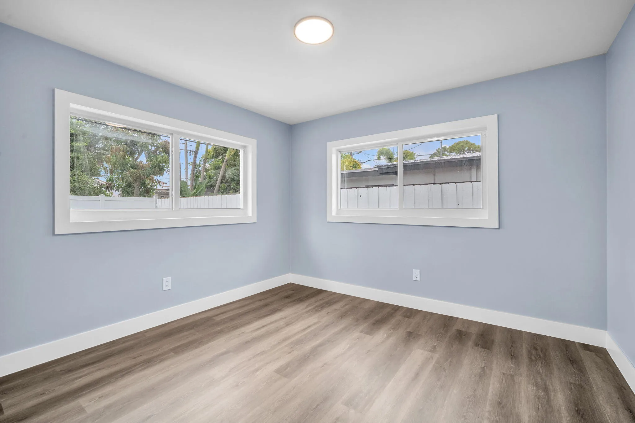 Wood-finish flooring with white trim and light blue walls