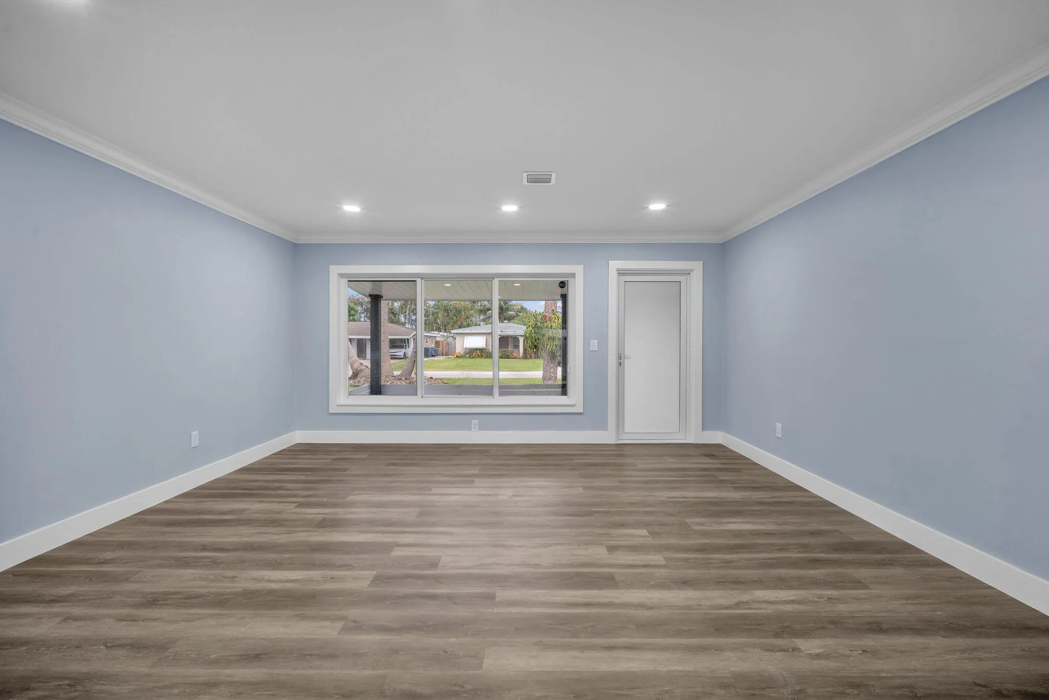 Recessed lighting, crown molding, wood-finish flooring, white trim, and a glass-paneled door