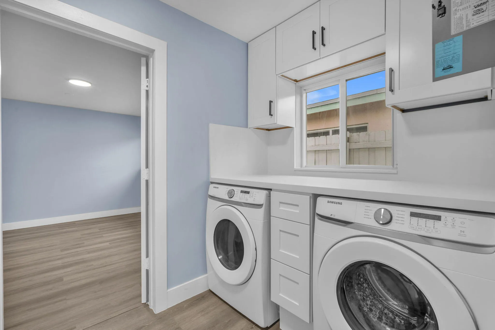Laundry area featuring a window, built-in white cabinetry, and a white countertop
