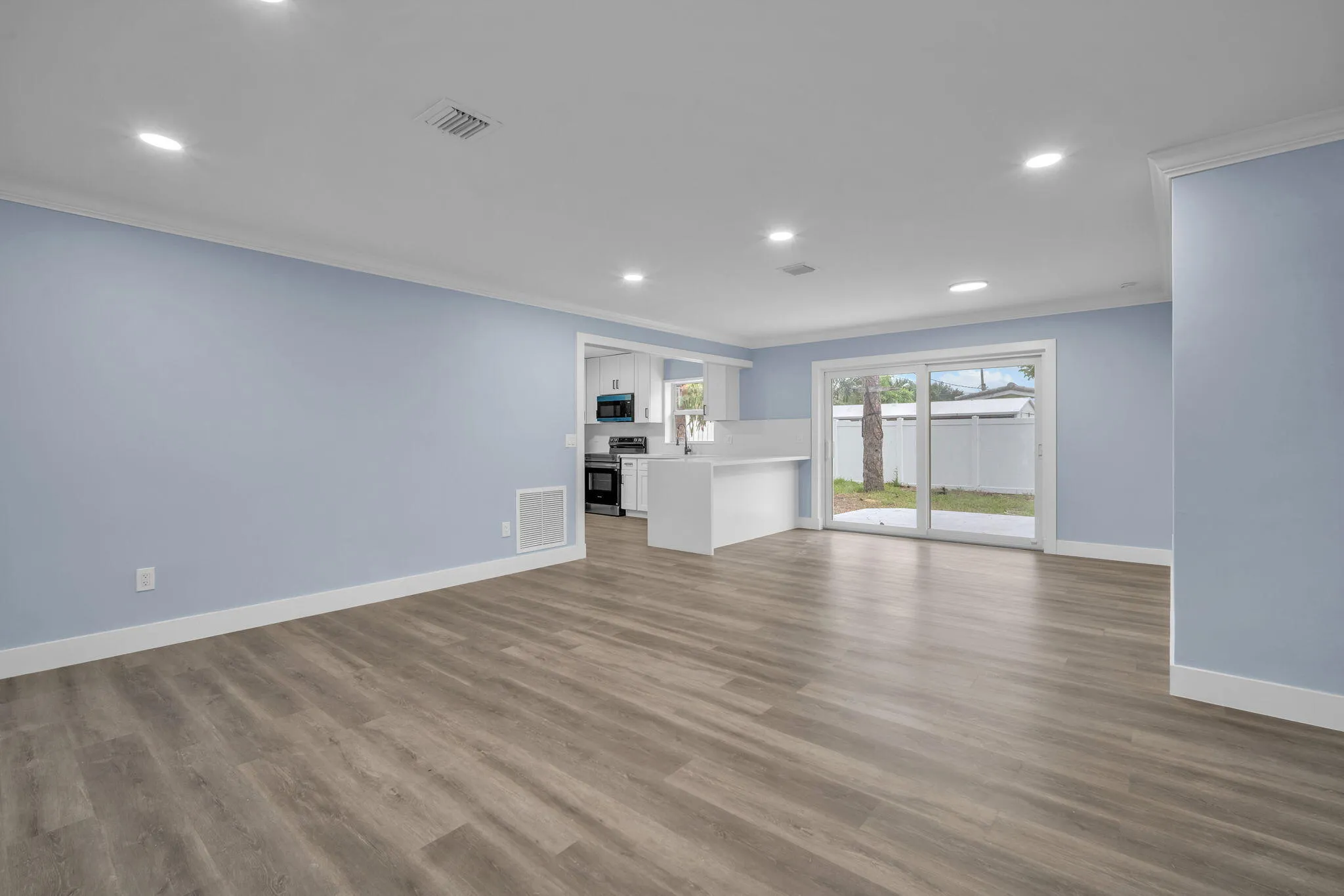 Wood-finish flooring, recessed lighting, and crown molding