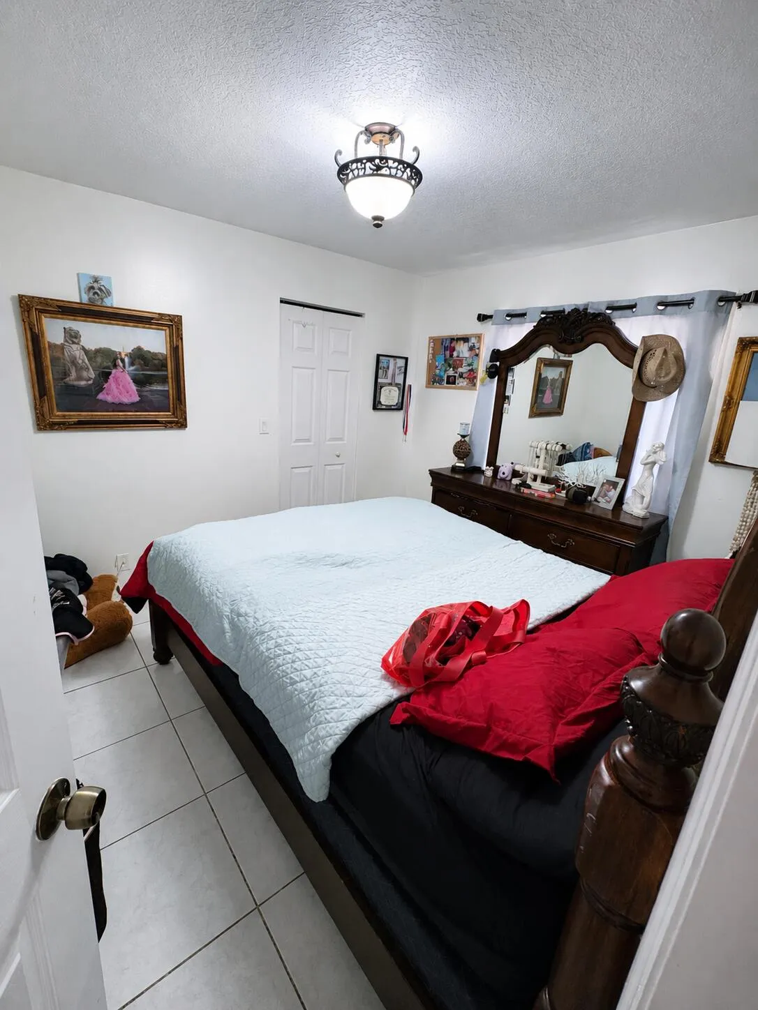 Recessed lighting with decorative fixture, tile flooring, and white bi-fold closet doors