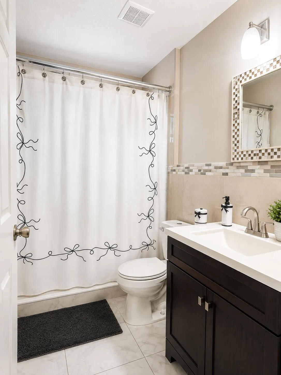 Bathroom featuring a dark wood-finish vanity with an integrated sink, tiled flooring, mosaic tile accents, and a wall-mounted light fixture