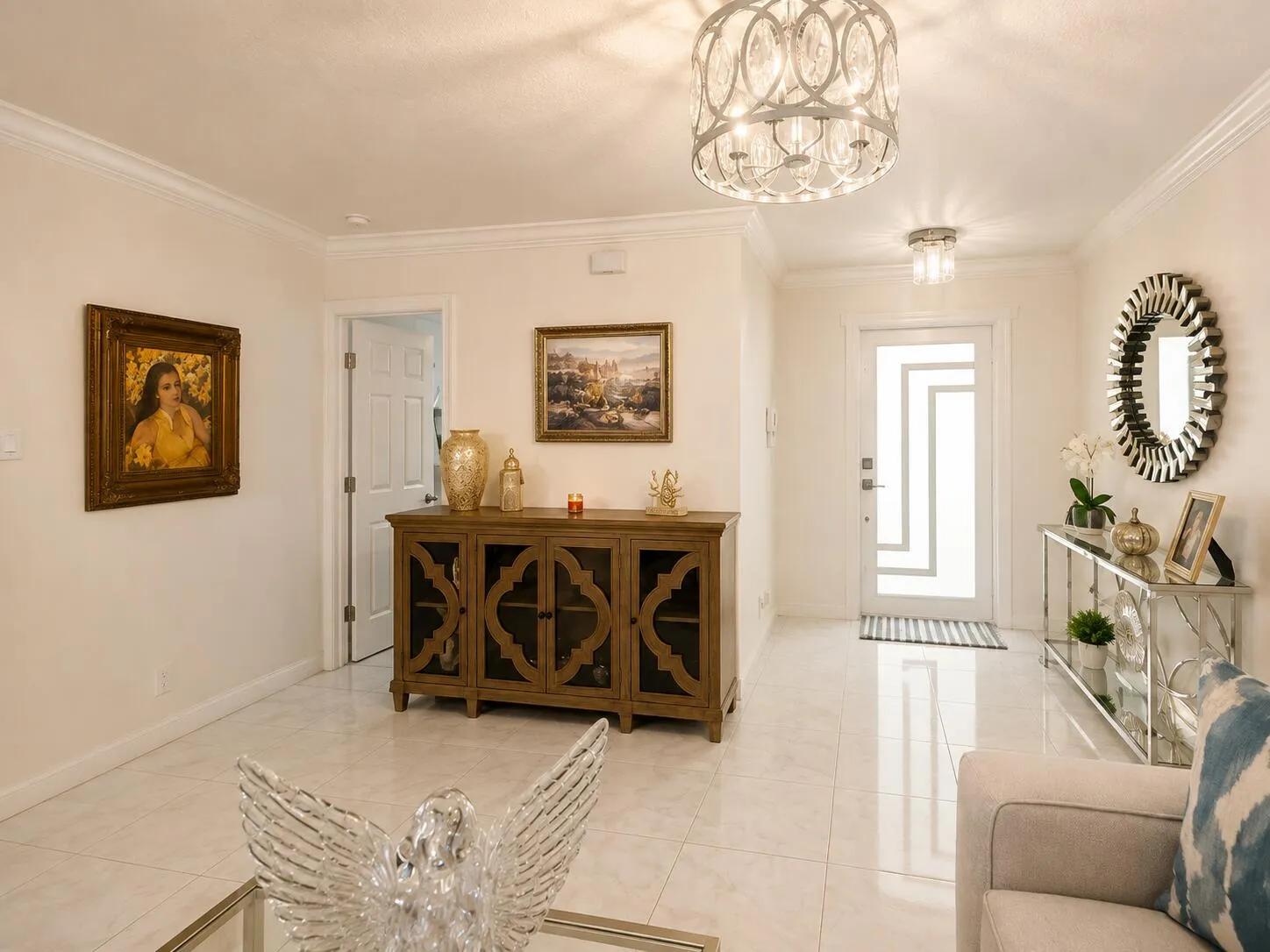 Smooth tile flooring throughout, crown molding, a decorative front entry door with frosted glass, and a stylish overhead light fixture