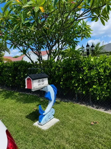 Manicured lawn with established landscaping and a decorative mailbox