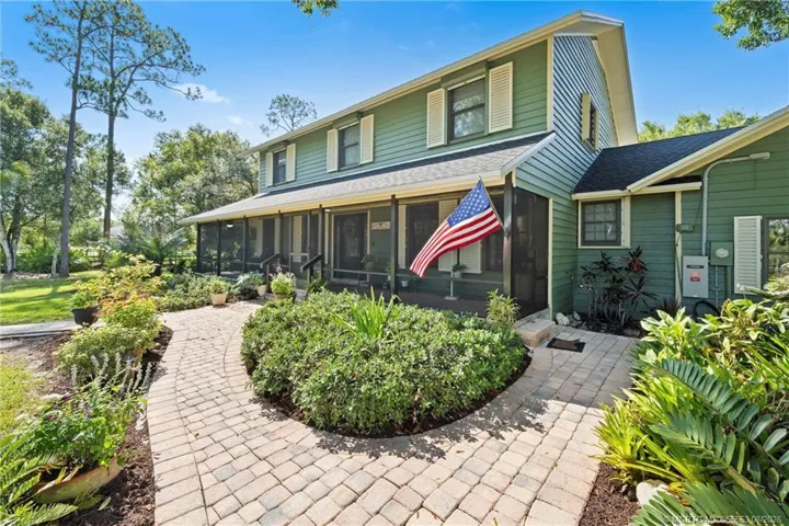 Front of home with screened wrap around porch.