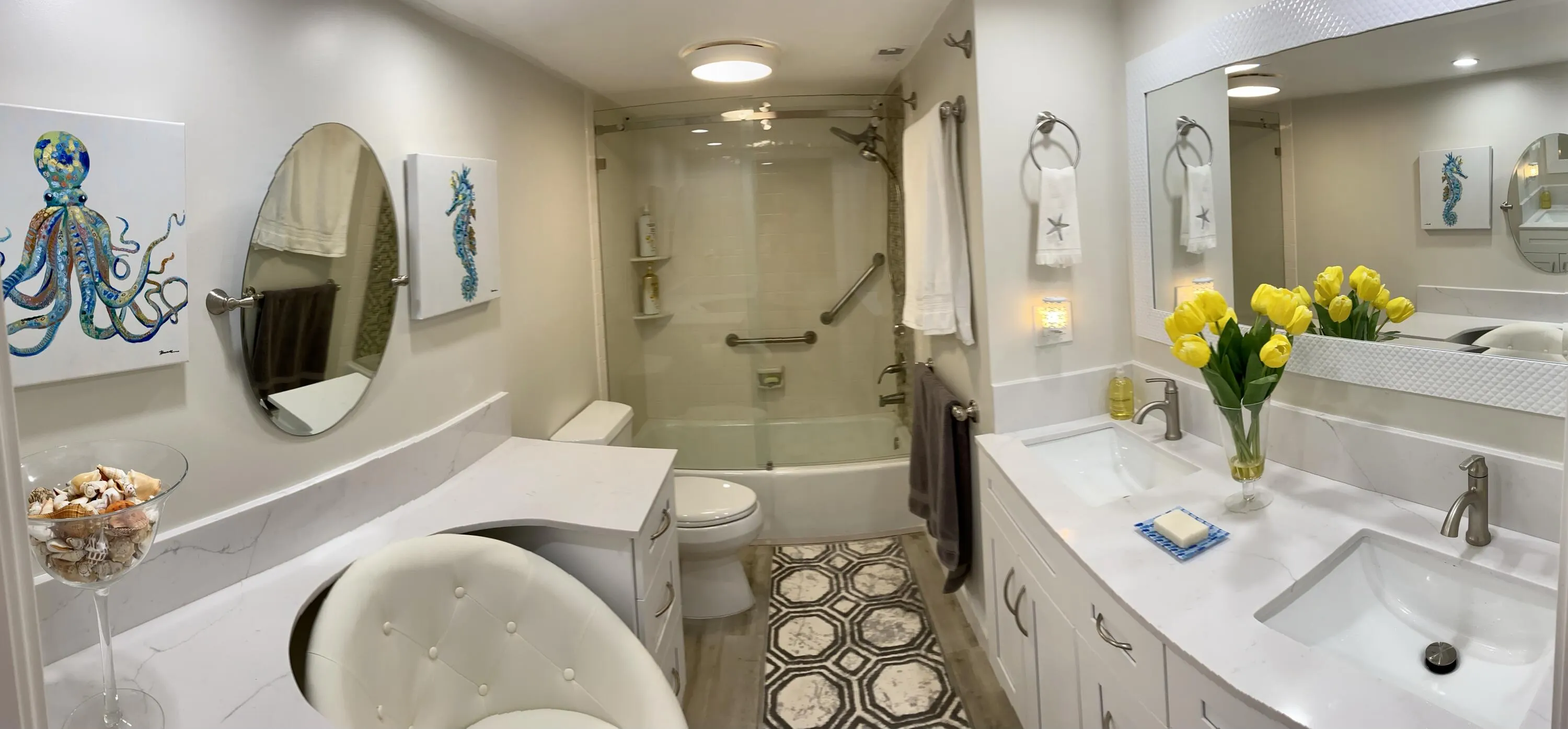 Bathroom featuring a dual vanity with undermount sinks, a built-in makeup counter, a full-size bathtub with a glass enclosure, and wood-finish flooring