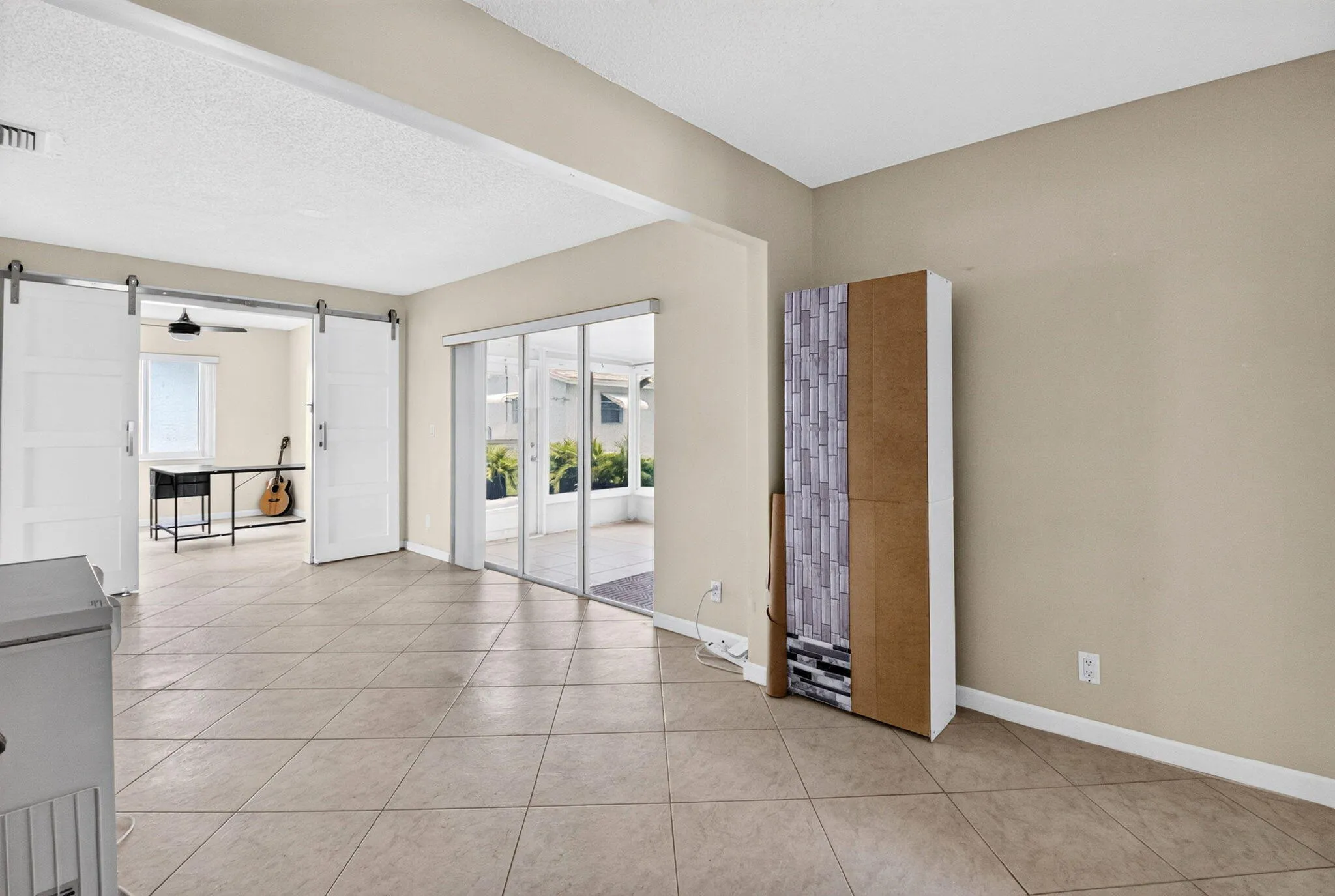 Tile flooring throughout, white barn doors, and sliding glass doors