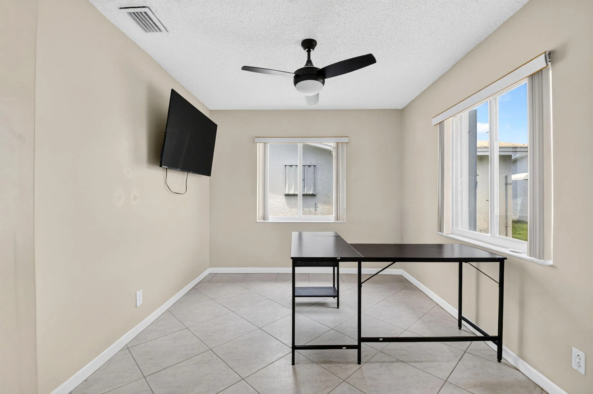 Recessed ceiling fan with integrated lighting, multiple windows providing natural illumination, tiled flooring, and neutral wall paint