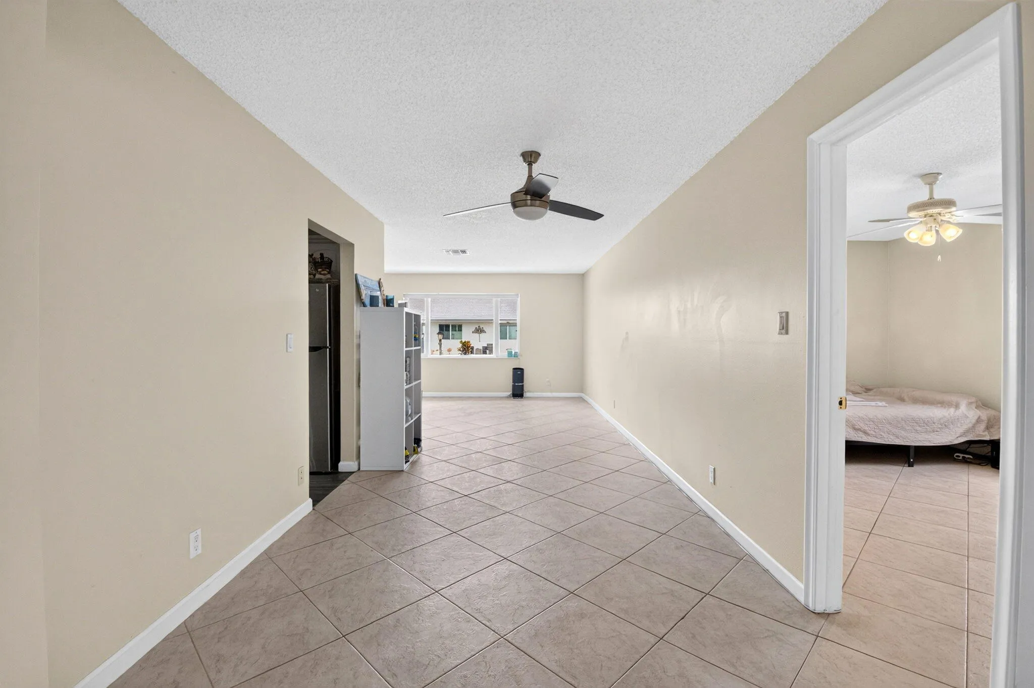 Tile flooring throughout, neutral painted walls, and ceiling fans