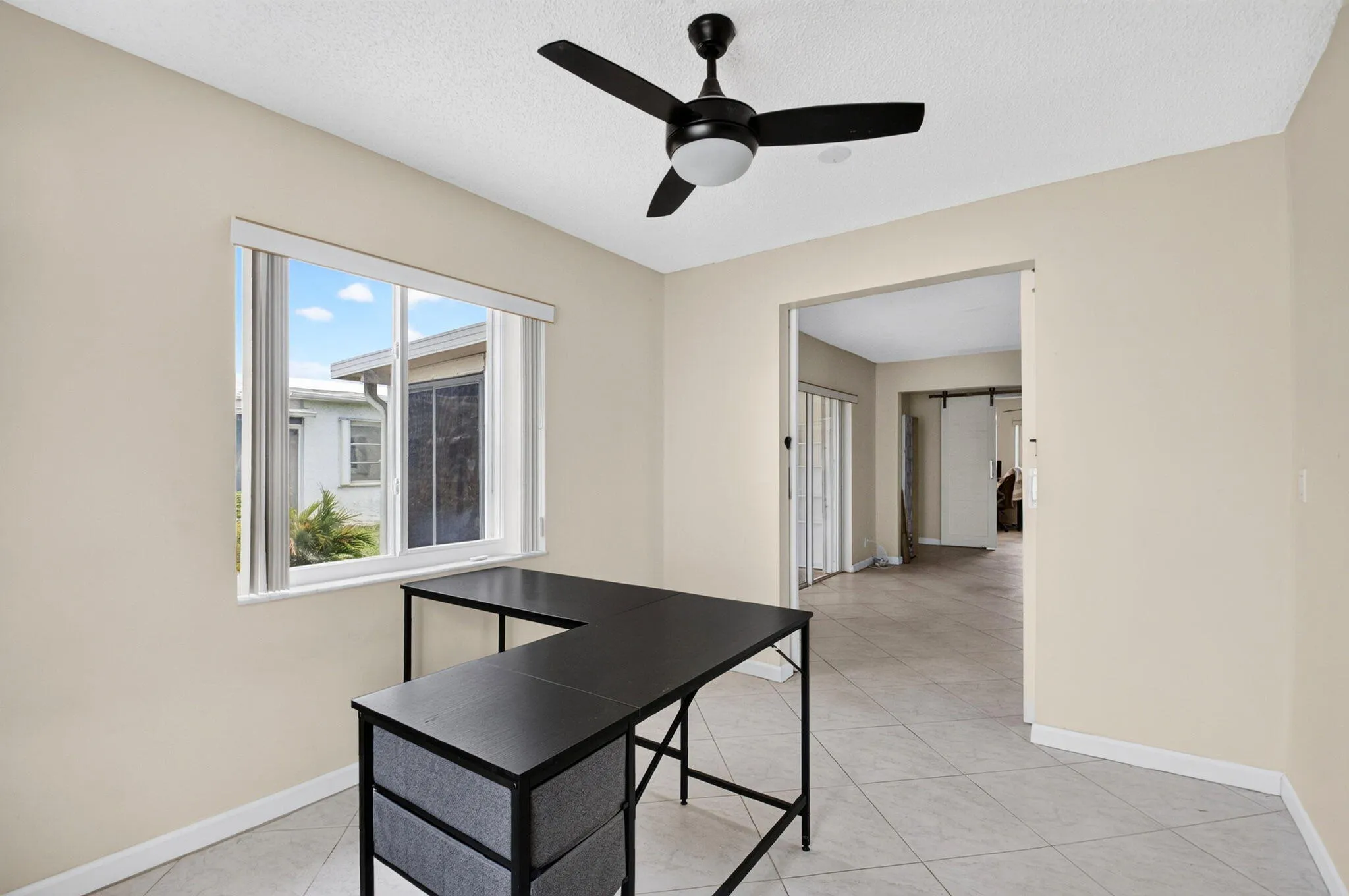 Recessed lighting, ceiling fan, neutral wall paint, tiled flooring, and a large window