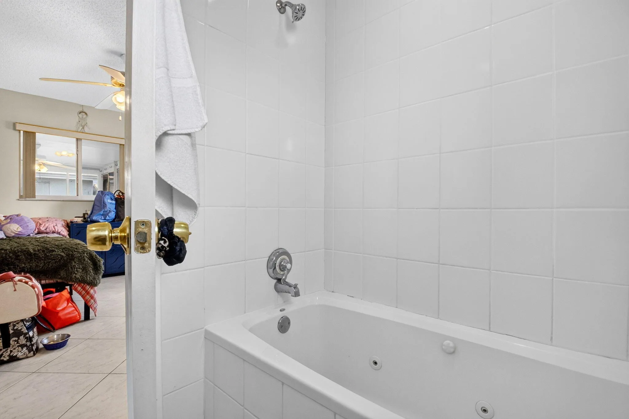 White tiled shower and tub combination with built-in jets