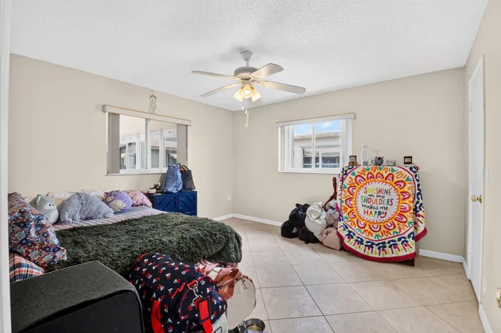 Recessed lighting, ceiling fan, neutral wall color, tiled flooring, and multiple windows
