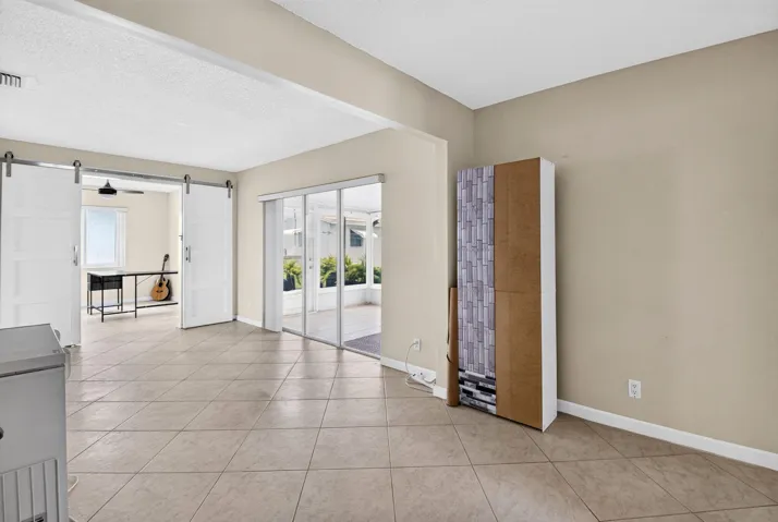 Tile flooring throughout, white barn doors, and sliding glass doors