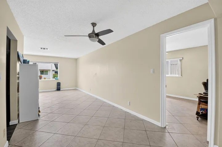 Neutral tone wall paint, tile flooring, ceiling fan, and recessed window