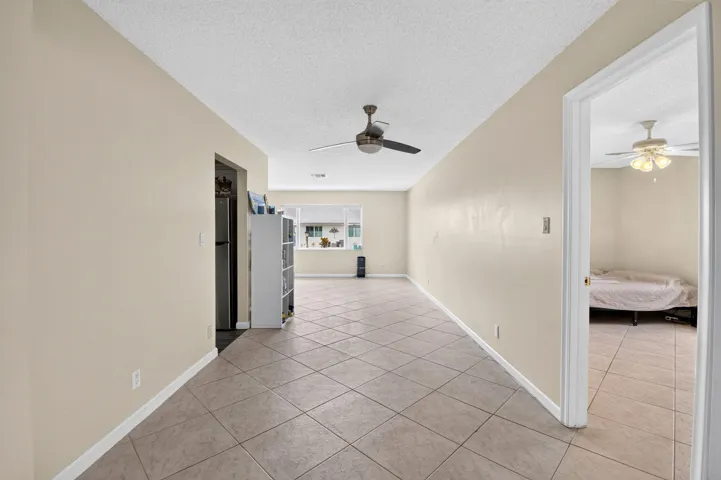 Tile flooring throughout, neutral painted walls, and ceiling fans