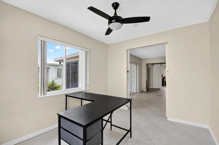 Recessed lighting, ceiling fan, neutral wall paint, tiled flooring, and a large window