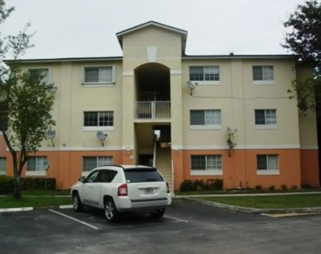 Three-story building with a central arched entrance and exterior stairwell