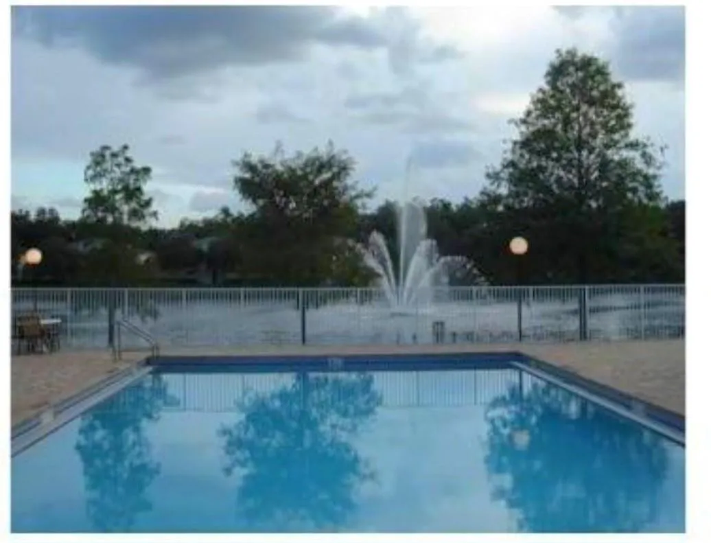 Swimming pool with light-toned decking and metal safety fencing