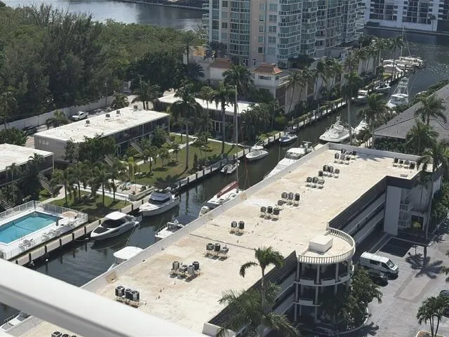Waterfront property with boat slips, mature palm trees, manicured lawns, and a swimming pool