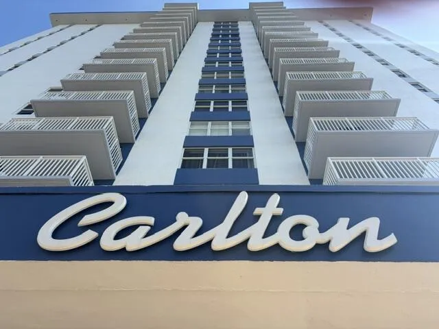 Building exterior featuring multiple balconies with white railings and blue accents