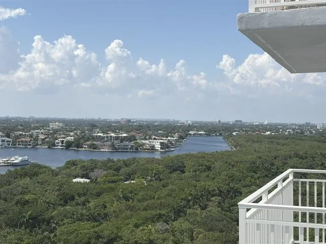 Expansive water and city scape from a balcony with white metal railings