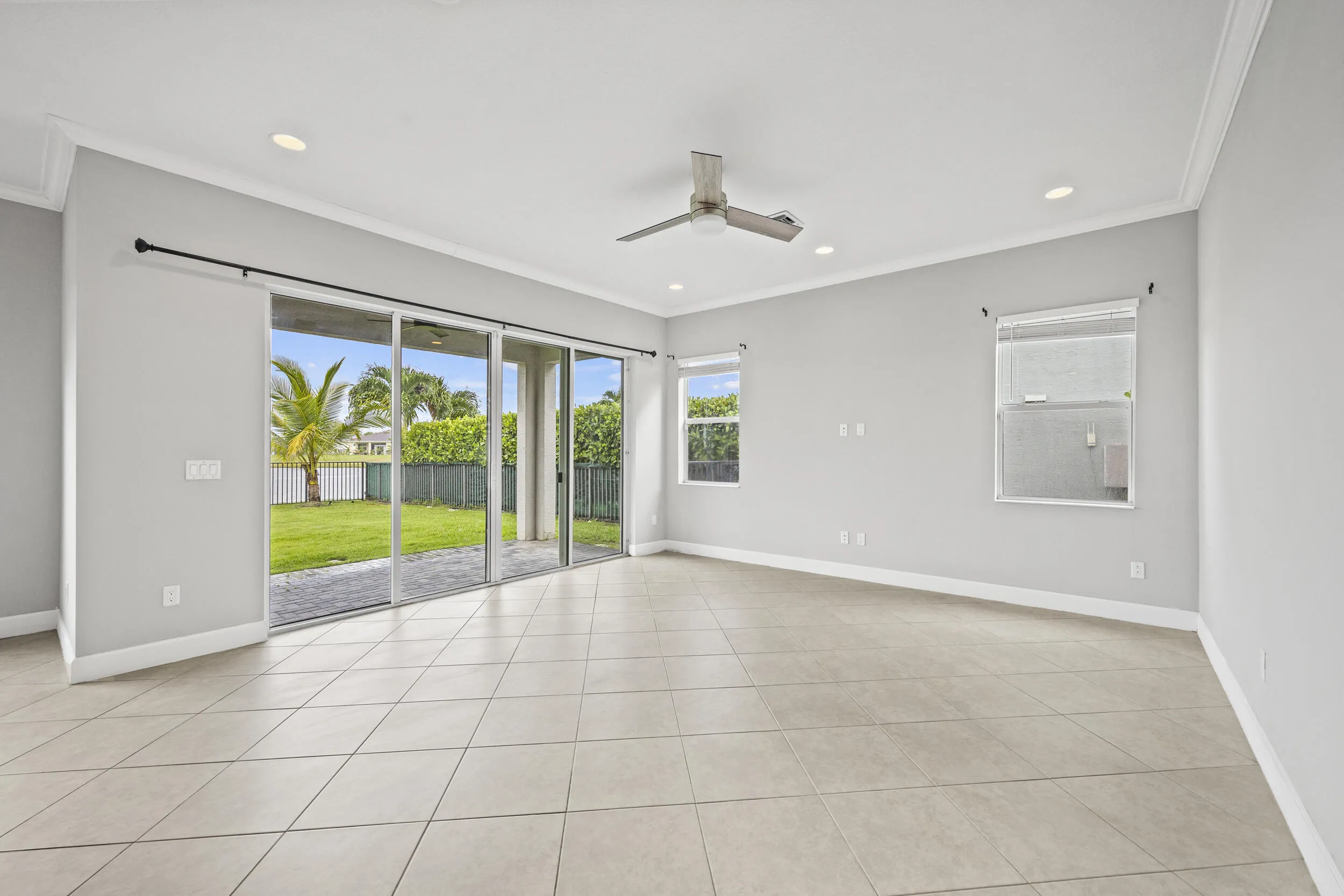 Spacious room with tile flooring, crown molding, recessed lighting, and a ceiling fan