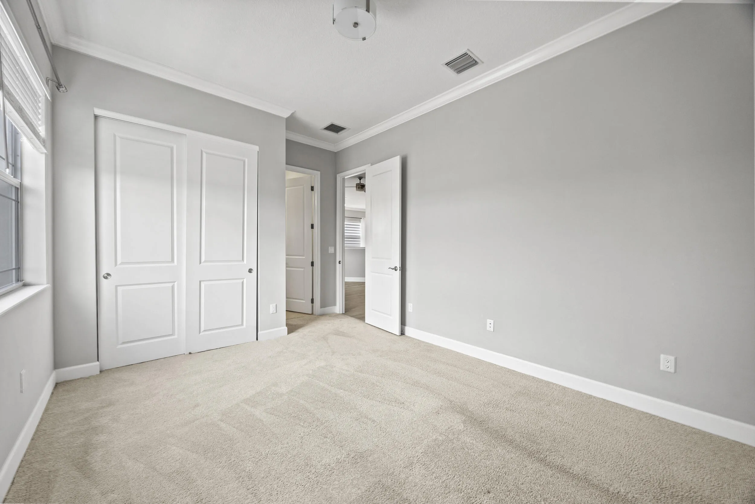 Plush carpeting, crisp white trim, crown molding, and bi-fold closet doors