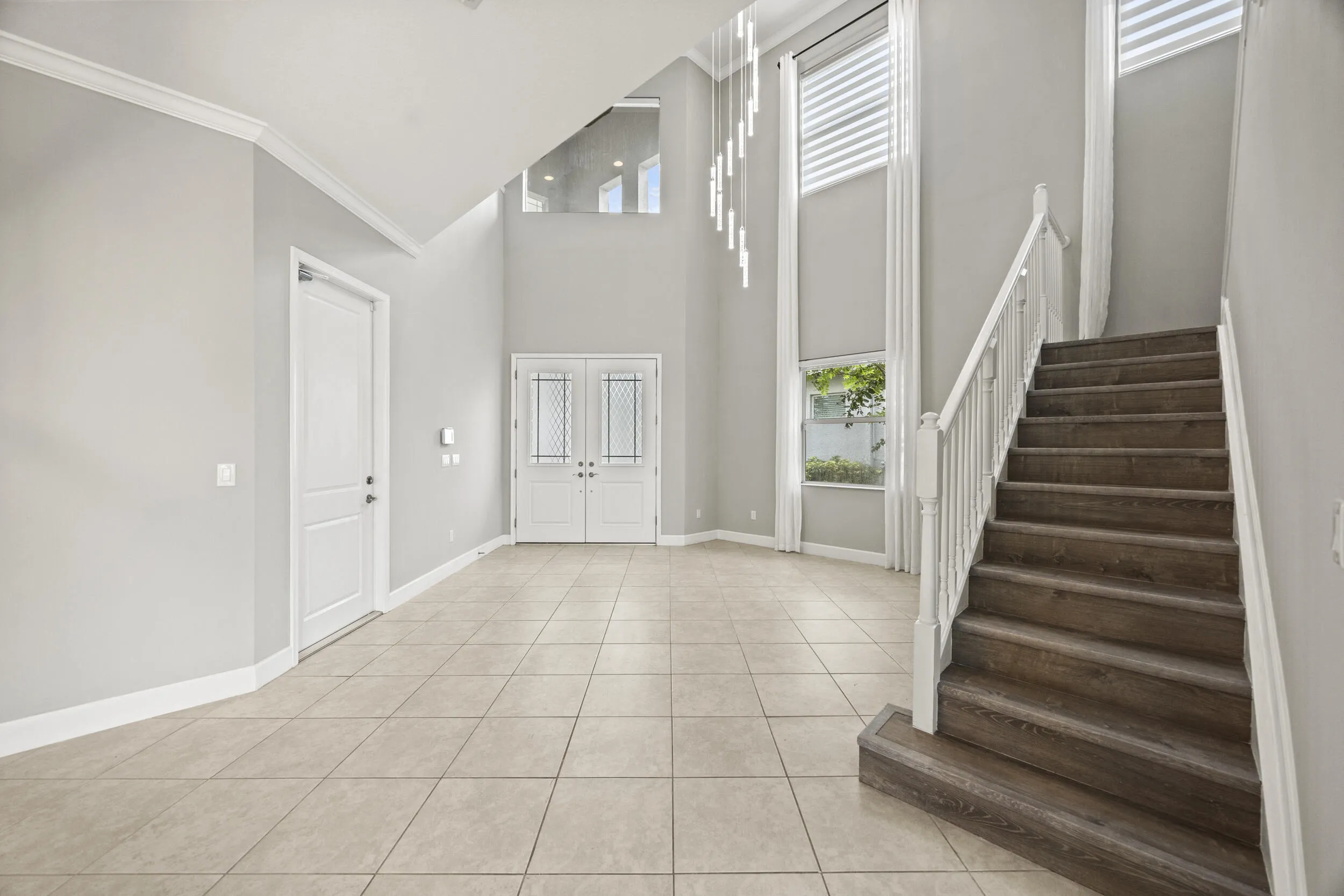Grand foyer with ceramic tile flooring and soaring ceiling