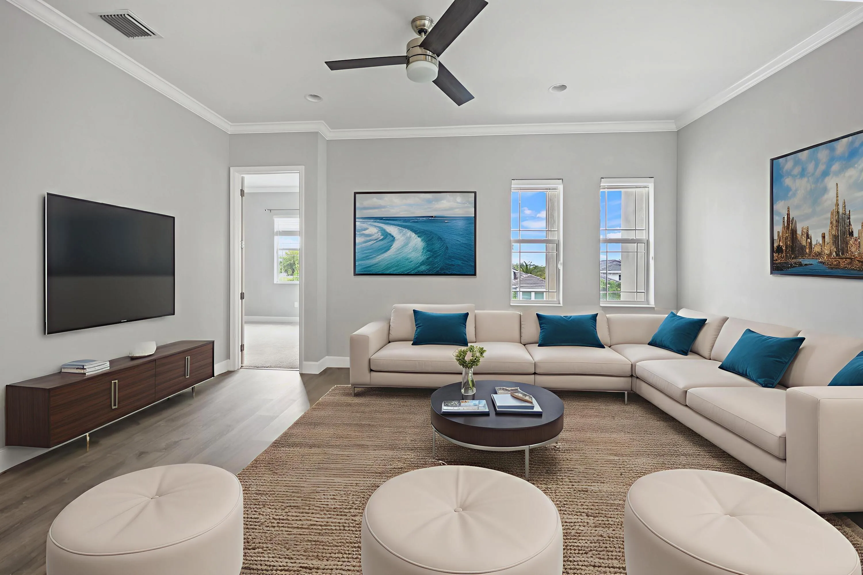 Spacious living area featuring wood-finish flooring, a ceiling fan, and crown molding
