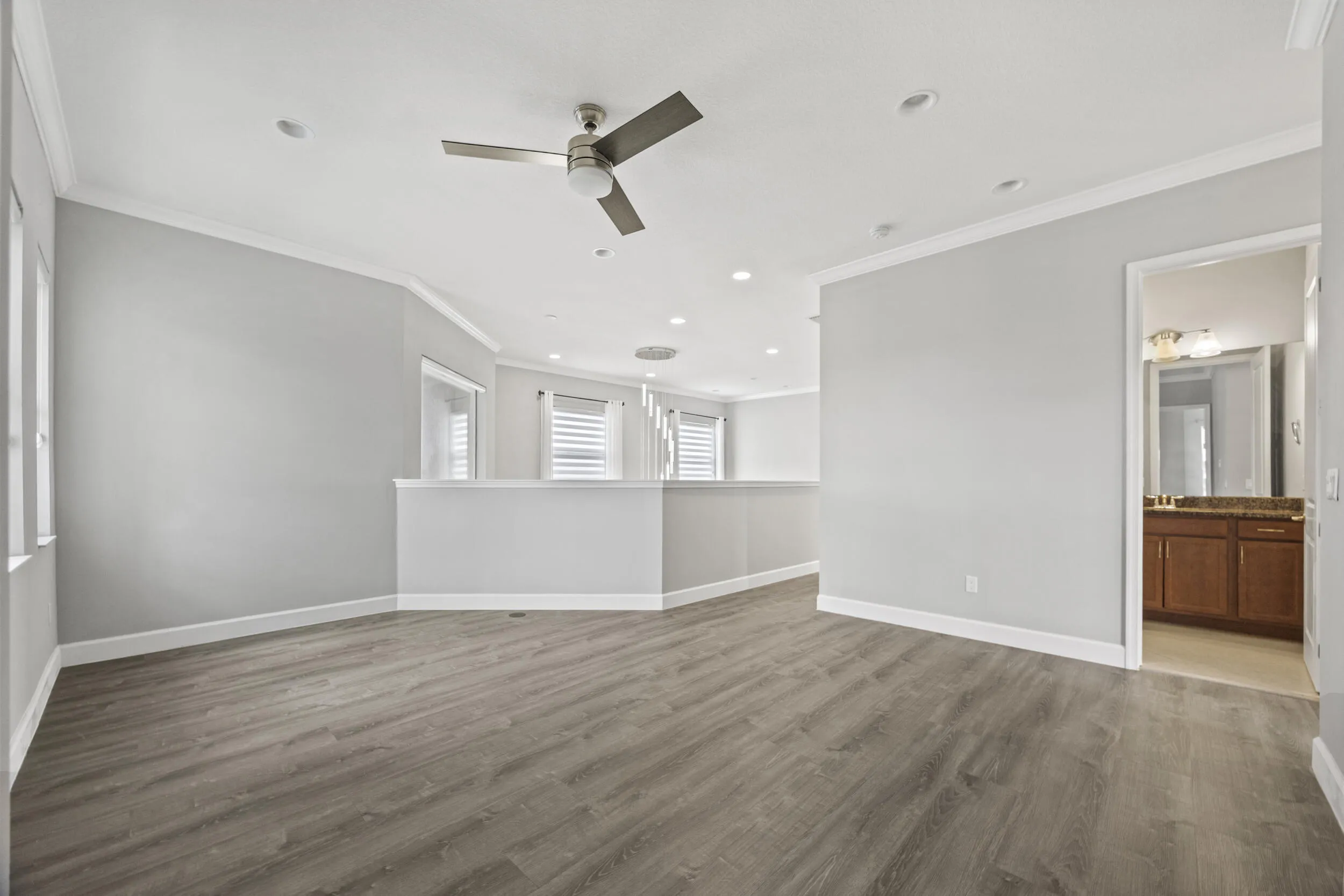 Recessed lighting, wood-finish flooring, ceiling fan, crown molding, and private bathroom access