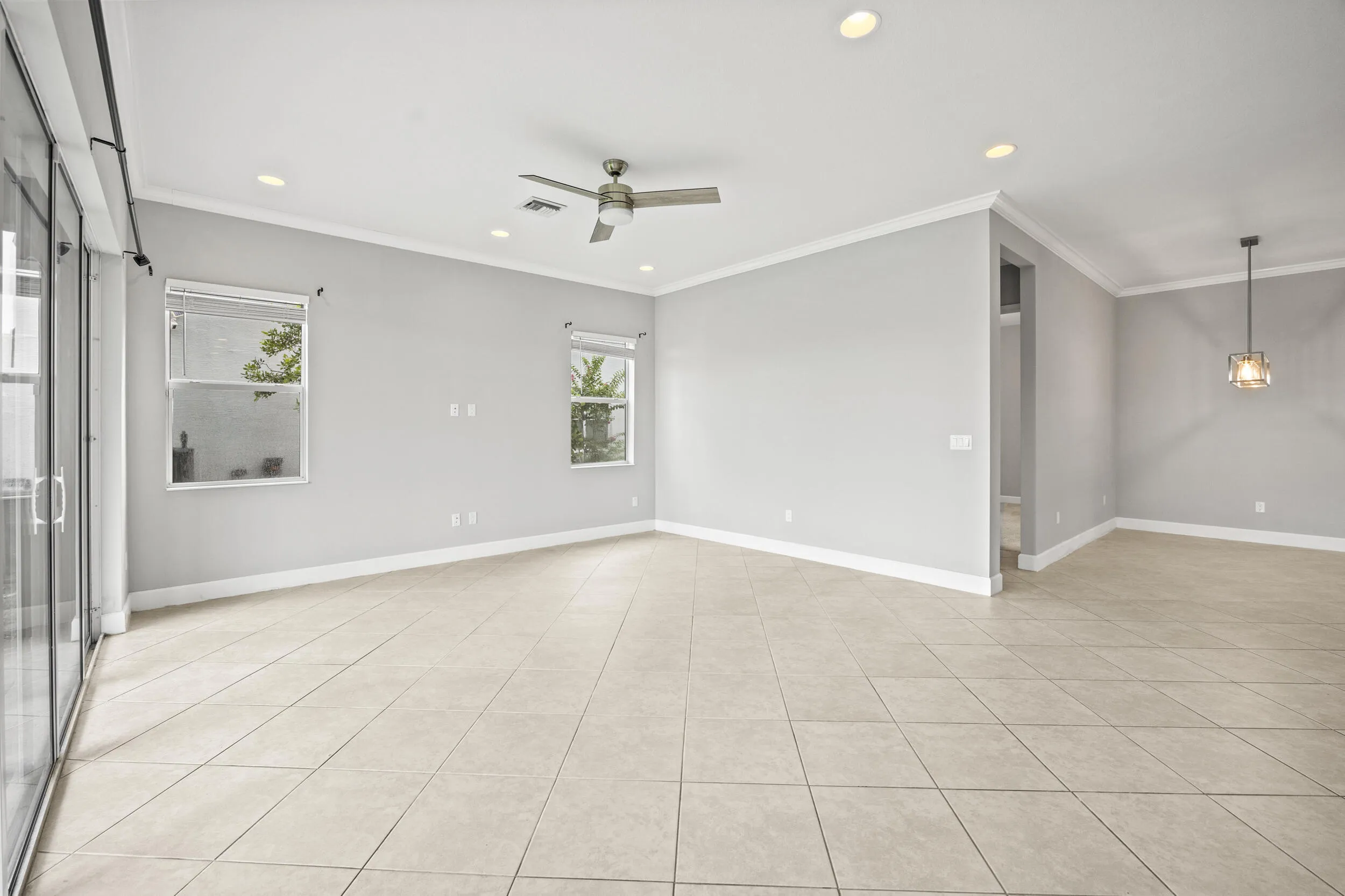 Expansive tile flooring, recessed lighting, ceiling fan, and crown molding
