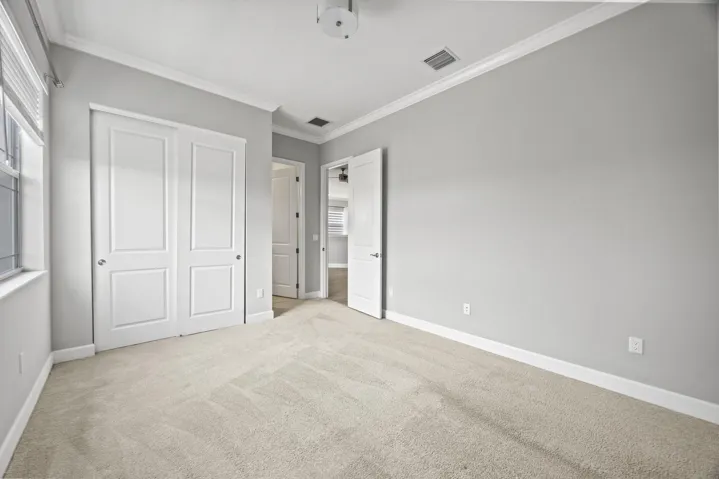 Plush carpeting, crisp white trim, crown molding, and bi-fold closet doors