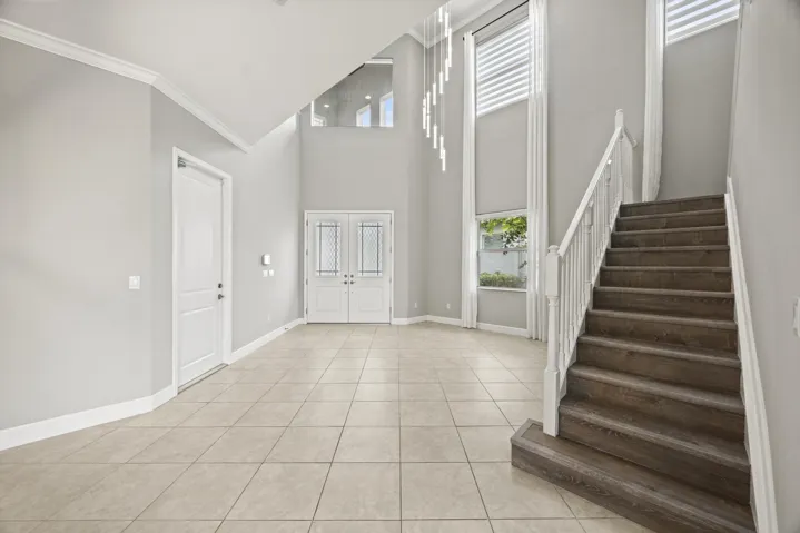 Grand foyer with ceramic tile flooring and soaring ceiling