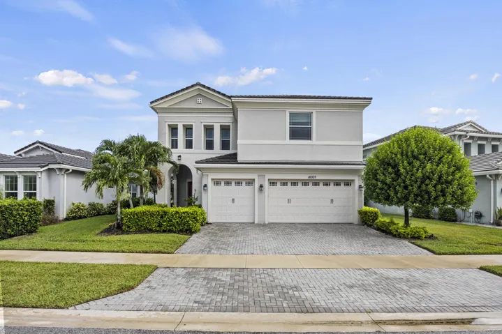 Modern two-story residence featuring a clean-lined architectural design with a gabled roofline and columned entry