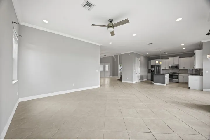 Expansive open-concept living area featuring tile flooring, recessed lighting, and a ceiling fan