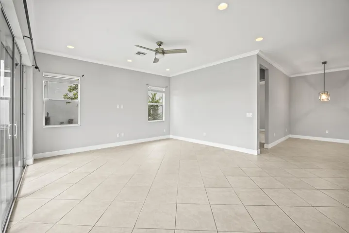 Expansive tile flooring, recessed lighting, ceiling fan, and crown molding